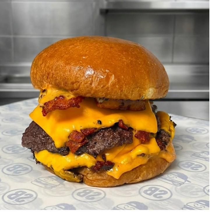 Suyo Burger doble carne con tocino, pepinillos y platanito frito